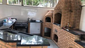a kitchen with a brick ovenasteryasteryasteryasteryasteryasteryasteryasteryasteryastery at Chácara/ Rancho Família Campos in Bicanca