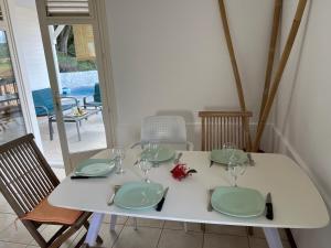 a white table with green plates and wine glasses at Villa Bambou in Le Vauclin