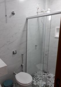 a bathroom with a toilet and a glass shower at Recanto Vovô João in Cunha