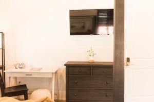 a bedroom with a dresser and a desk with a window at Haven House in Pensacola