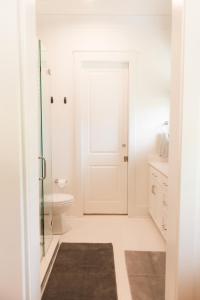a bathroom with a toilet and a glass door at Haven House in Pensacola