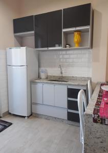a kitchen with a white refrigerator and a table at Recanto Vovô João in Cunha