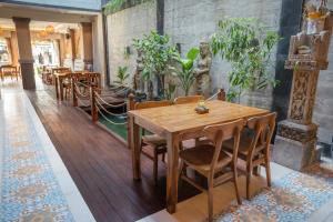 een eetkamer met een houten tafel en stoelen bij Vimala Ubud in Ubud
