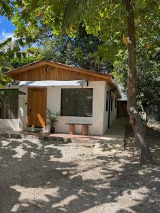 una pequeña casa blanca con un árbol delante en Beautiful 2-bedroom home OR Studio Apartment OPTION in Santa Cruz en Santa Cruz