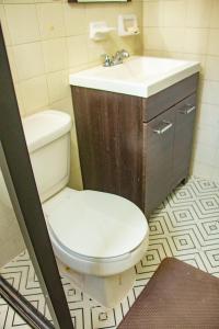 ein Badezimmer mit einem weißen WC und einem Waschbecken in der Unterkunft Departamento Olas in Tuxtla Gutiérrez