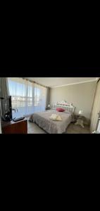 a bedroom with a bed and a desk and a window at II Cerca de la playa y del centro in La Serena