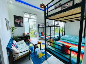 Zimmer mit 2 Etagenbetten und einem Sofa in der Unterkunft Minh House in Ấp Ða Lợi
