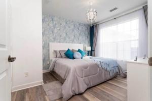 Un dormitorio con una cama grande con almohadas azules. en Beautiful Orlando Apt with Nemo Bedroom, 15 min to Disney!, en Kissimmee