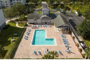 - une vue aérienne sur une piscine avec des chaises et une maison dans l'établissement Beautiful Orlando Apt with Nemo Bedroom, 15 min to Disney!, à Kissimmee