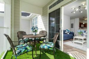 Un patio con una mesa y sillas y un sofá. en Beautiful Orlando Apt with Nemo Bedroom, 15 min to Disney!, en Kissimmee
