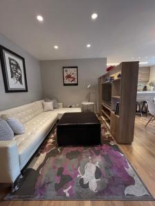 a living room with a white couch and a rug at Modern Apartment in the Heart of Quito in Quito