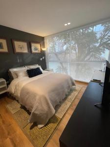 a bedroom with a large bed and a large window at Modern Apartment in the Heart of Quito in Quito