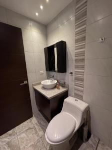 a bathroom with a toilet and a sink at Modern Apartment in the Heart of Quito in Quito