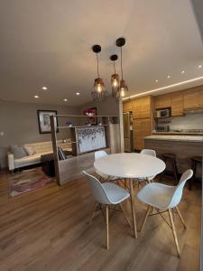 a kitchen and living room with a table and chairs at Modern Apartment in the Heart of Quito in Quito