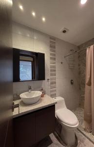 a bathroom with a white sink and a toilet at Modern Apartment in the Heart of Quito in Quito