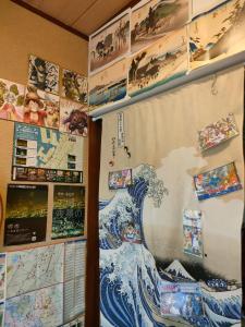 eine Wand mit einer Welle und Bildern darauf in der Unterkunft MIROKU Share House in Mimiharachō