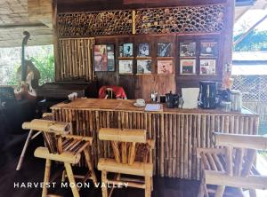 a room with a wooden counter with chairs and a table at Harvest Moon Valley in Ban Pang Luang