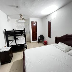 a bedroom with a bed and a bunk bed at Hostal Taganga Plaza in Taganga