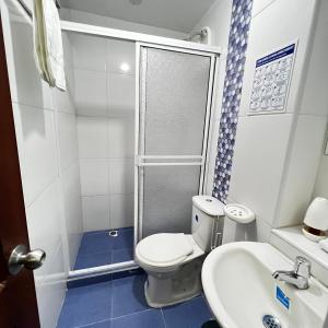 a small bathroom with a toilet and a sink at Hostal Taganga Plaza in Taganga