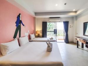 ein Zimmer mit 2 Betten und ein Bild einer Frau an der Wand in der Unterkunft Bella Villa Pattaya 3rd Road in Pattaya