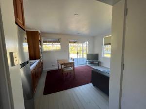 a kitchen and living room with a table and a couch at Glenaire Apartments at Frazer St in Strahan