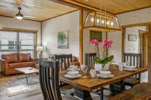 une salle à manger avec une table en bois et des fleurs. dans l'établissement Osprey Nest Cottage Modern New Cabin, à Pigeon Forge