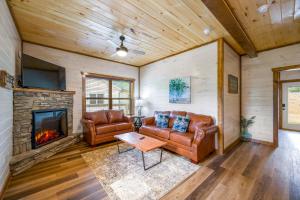 sala de estar con muebles de cuero y chimenea en Osprey Nest Cottage Modern New Cabin en Pigeon Forge