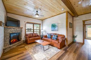 a living room with leather furniture and a fireplace at Osprey Nest Cottage Modern New Cabin in Pigeon Forge