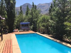a swimming pool with a chair and mountains in the background at Cabaña El Ingenio in El Ingenio