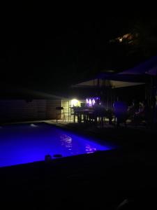 einen Pool in der Nacht mit einem Tisch und Lampen in der Unterkunft Cabaña El Ingenio in El Ingenio
