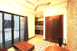 ein Wohnzimmer mit einem Deckenventilator und einer Holztür in der Unterkunft Theary apartment in Phumĭ Ta Phŭl