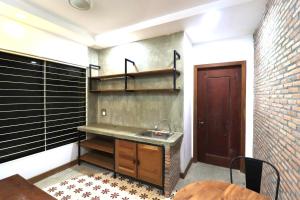 eine Küche mit Spüle und Ziegelwand in der Unterkunft Theary apartment in Phumĭ Ta Phŭl