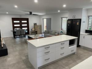 a kitchen and living room with a white counter top at Cairns / Edge Hill Stylish Villa A in Edge Hill