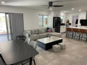 ein Wohnzimmer mit einem Sofa und einem Tisch in der Unterkunft Cairns / Edge Hill Stylish Villa A in Edge Hill