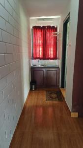 a kitchen with a red curtain in a room at The Four Seasons in Kalpetta