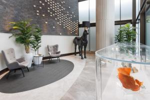 a lobby with a glass table and a horse statue at Meriton Suites George Street, Parramatta in Sydney