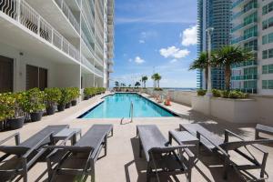 a swimming pool in a building with tables and chairs at Superb unit, centrally located with parking in Miami