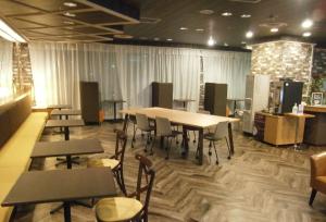 ein Restaurant mit Tischen und Stühlen in einem Zimmer in der Unterkunft The Celecton Takamatsu in Takamatsu