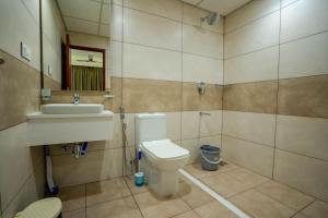 a bathroom with a toilet and a sink at AS Inn in Ernakulam