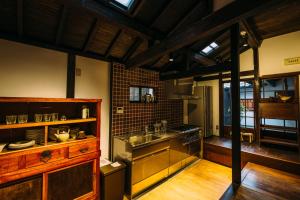 een keuken met een wastafel en een fornuis bij taos 丹波の風土を感じられる一棟貸切の宿 in Sasayama