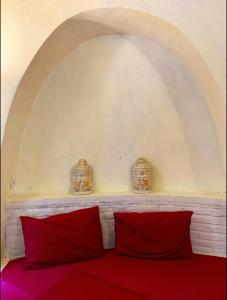 Habitación con 2 almohadas rojas en una cama roja. en Villa Kingdome - 1 Bedroom, en Teluknarat