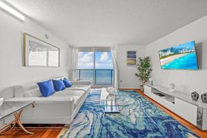 sala de estar con sofá blanco y alfombra azul en Spacious Ocean view unit in the heart of Brickell, en Miami