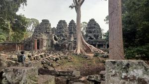 a boy standing in front of an ancient temple at Kakrona Pouk Homestay in Siem Reap