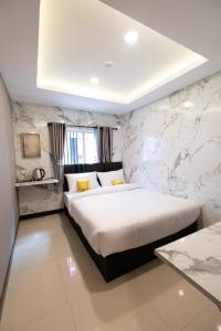 a bedroom with a large bed and a marble wall at Amber Inn in Bangkok