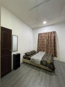 a small bedroom with a bed and a curtain at DakNan Homestay Duyong in Malacca