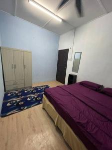a bedroom with a purple bed in a room at DakNan Homestay Duyong in Malacca