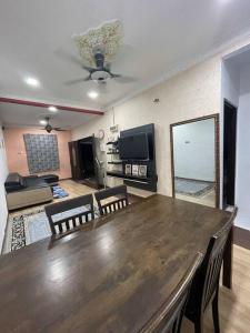 a living room with a large wooden table and chairs at DakNan Homestay Duyong in Malacca