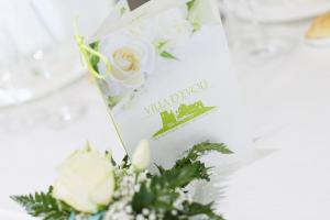 a table with a white flower arrangement and a menu at Hotel Villa d'Evoli in Castropignano