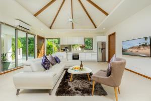 a living room with a white couch and a table at Laem Ka Residence by Tropiclook in Rawai Beach