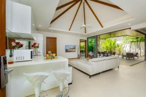 a living room with a white couch and a table at Laem Ka Residence by Tropiclook in Rawai Beach